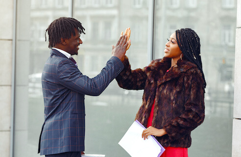 Two Pan-African Council members greeting each other in a professional setting